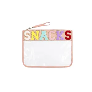 Macro view of pink transparent pouch featuring colorful chenille SNACKS letter embroidery