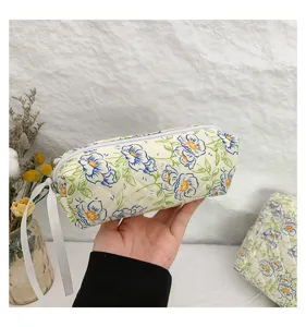 Close-up detail showing the quilted texture and floral pattern of the cotton cosmetic bag