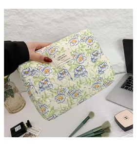 Detail view of floral quilted cotton cosmetic bag showing texture and hand-held scale