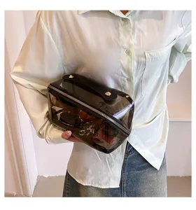Close-up of a stylish transparent black travel wash bag with a leather handle.