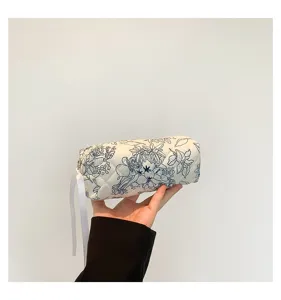 Detailed view of the quilted floral cotton cosmetic bag being held to show size