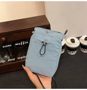 Primer plano de funda de móvil en lona azul claro con cordón ajustable y correa negra