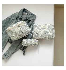 Set of three floral quilted cotton cosmetic bags displayed with a denim jacket