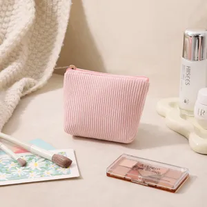 Nahaufnahme einer rosa Kosmetiktasche aus Kord mit einem eleganten goldenen Reißverschluss