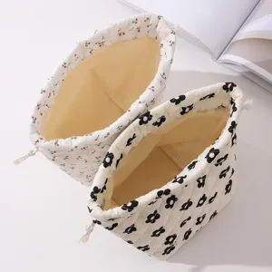 Detailed view of quilted floral drawstring makeup bags with cherry and flower prints