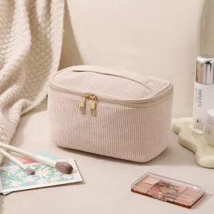 Detailansicht der beigen Kordstoffstruktur einer großen Kosmetiktasche im Detail