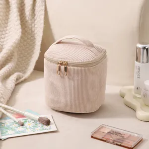 Nahaufnahme einer beige Cord-Kosmetiktasche mit goldenen Reißverschlüssen
