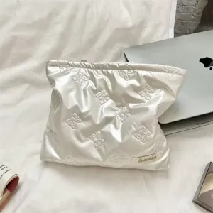 Detail view of a white quilted PU pouch with heart patterns on a lifestyle work desk