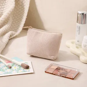 Detailaufnahme einer minimalistischen beige Cord-Kosmetiktasche mit goldenem Reißverschluss