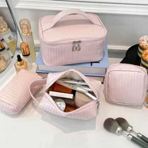 Macro detail of pink quilted PU leather makeup bag set on a vanity table with accessories.