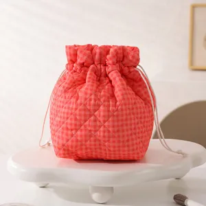 Detailed macro shot of red checkered quilted fabric drawstring cosmetic storage pouch