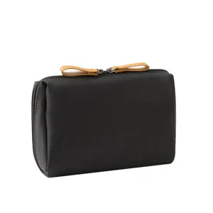 Sleek black mini makeup storage bag featuring dual tan leather zipper pulls on top