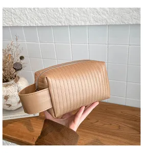 Detailed view of beige quilted PU leather waterproof cosmetic bag with a wide handle