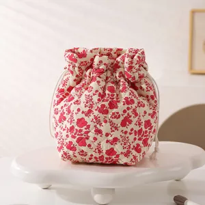 Detailed view of the delicate red floral quilted pattern on a drawstring cosmetic bag