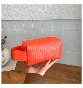Close-up detail of vibrant orange cake-textured waterproof PU leather makeup storage bag
