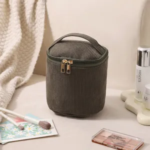 Nahaufnahme einer dunkelgrünen Cord-Kosmetiktasche mit Kosmetik.