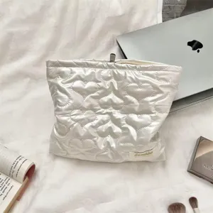 White quilted PU heart-pattern cosmetic bag with zip closure for makeup storage.