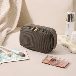 Detailansicht der dunkelgrünen Cord-Kosmetiktasche mit goldenen Reißverschlüssen