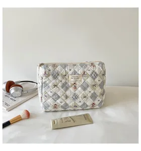 Close-up of the textured quilted fabric and cute embroidered bears on the soft cosmetic bag.