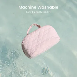 Water-resistant pink quilted makeup bag floating on water, machine washable feature.
