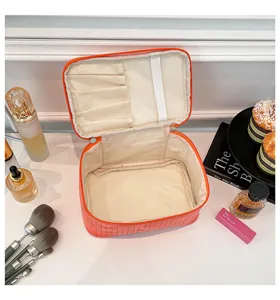Close-up view of the interior slots and main compartment of the orange PU leather makeup bag
