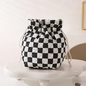 Black and white checkered quilted drawstring makeup bag on a white display stand