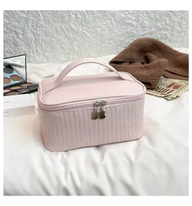 Large capacity pink PU leather makeup organizer bag displayed in a cozy lifestyle setting
