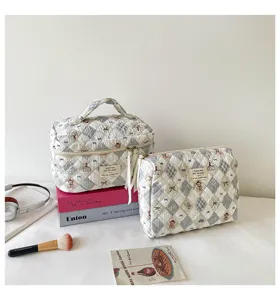 Detail view of quilted bubble cosmetic bags in blue diamond pattern on cream background
