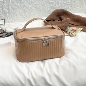 A quilted tan PU leather cosmetic bag featuring a sturdy handle and dual moon-shaped zippers