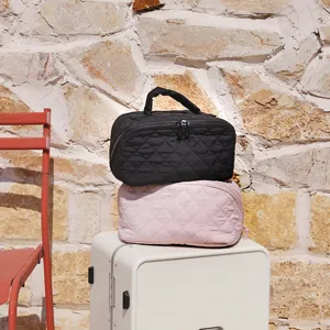 Detail showing the quilted texture of black and pink handheld travel cosmetic bags