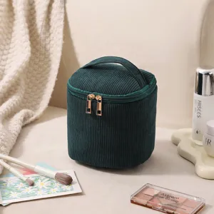 Detailansicht der dunkelgrünen Cord-Kosmetiktasche mit eleganten Gold-Reißverschlüssen