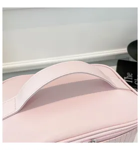 Close-up detail of the durable handle on a pink waterproof PU leather makeup bag.