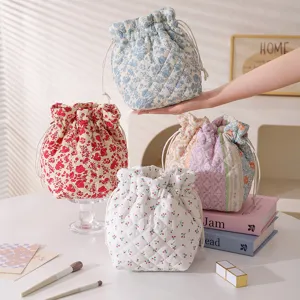 Detail showing assorted floral quilted drawstring storage pouches for cosmetics