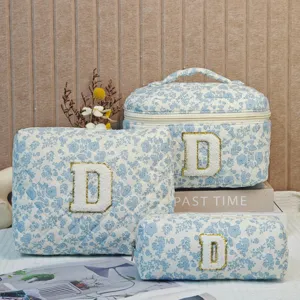Set of three blue floral quilted cotton cosmetic bags with embroidered letter D patches
