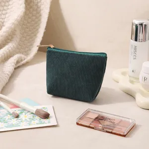 Nahaufnahme einer grünen Cord-Kosmetiktasche auf Schminktisch