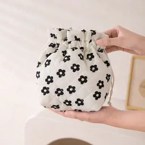 Macro view of white quilted floral drawstring storage bag showing soft fabric texture
