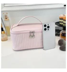 Detailed view of the pink quilted PU leather makeup bag next to a smartphone for scale.