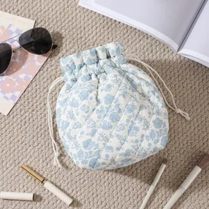 Close-up detail of a floral quilted drawstring makeup bag in a cozy lifestyle setup