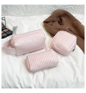Detail view of pink PU leather cosmetic bag set featuring vertical quilted texture