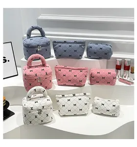 Close-up detail of corduroy cosmetic bags with bow print in multiple colors and styles