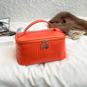 Large orange PU leather cosmetic bag with quilted texture and sturdy top handle