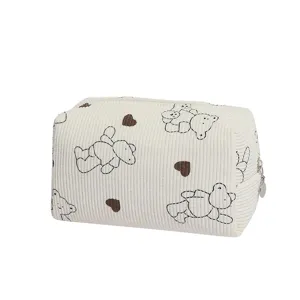 Detail shot of the cream corduroy pouch showing the cute bear and heart print pattern.