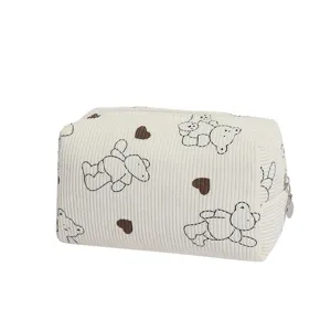 Detailed view of a cream corduroy cosmetic bag with black bear and heart patterns