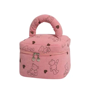 Close-up showing the pink corduroy texture and cute bear patterns on travel bag