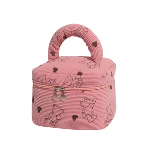 Pink corduroy cosmetic bag with cartoon bear and heart pattern for travel organization.