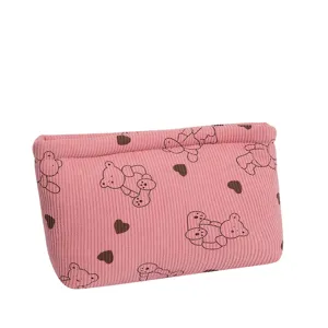 Close-up view of pink corduroy pouch with bear and heart prints for travel storage