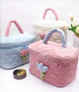 Detailed view of corduroy cosmetic bags with tulip decor in pink, blue, and white