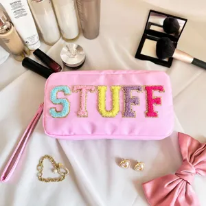 Gros plan d'une trousse à maquillage rose avec écussons colorés STUFF en chenille