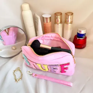 Gros plan sur la trousse à maquillage en nylon rose avec broderie chenille STUFF colorée