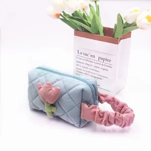 Detail of blue corduroy cosmetic bag with pink tulip patch and ruffled handle